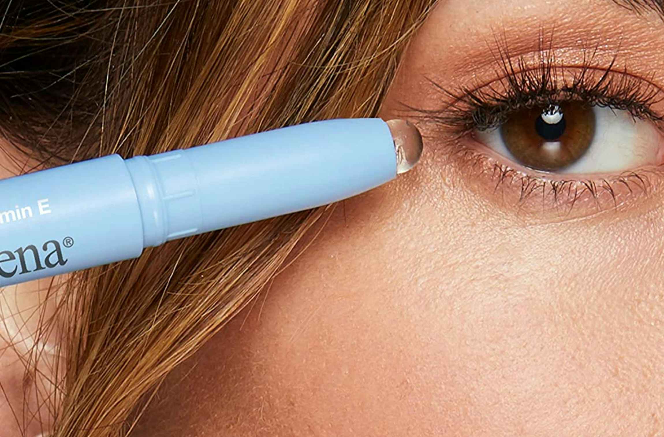 person holding a neutrogena makeup eraser stick near their eye