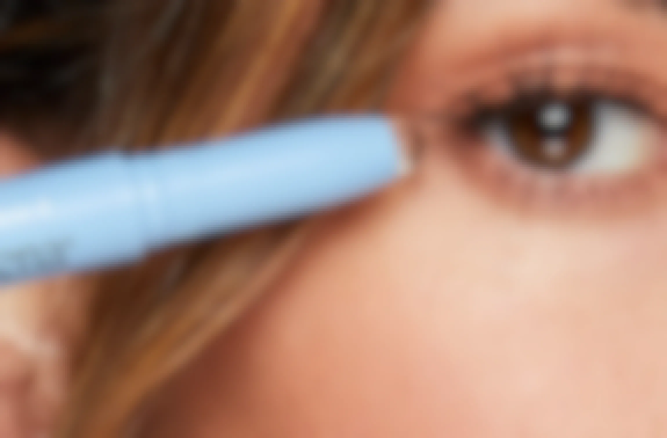 person holding a neutrogena makeup eraser stick near their eye