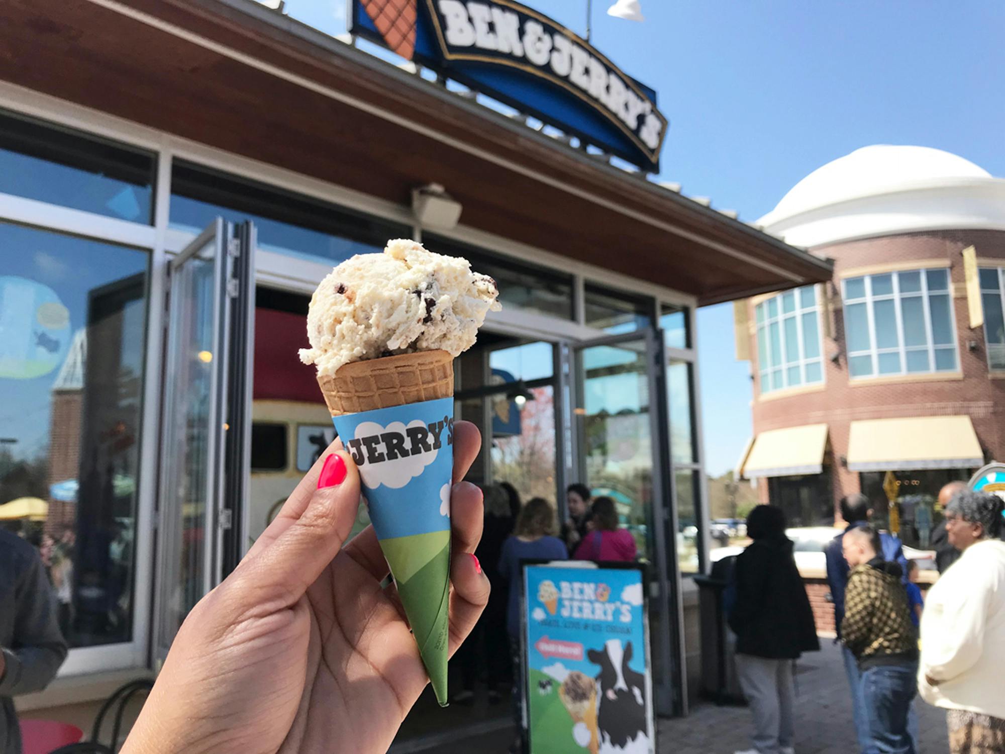 person holding a ben and jerry's ice cream cone