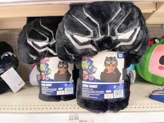 Two Black Panther hooded towels sitting on a store shelf above a price sticker.