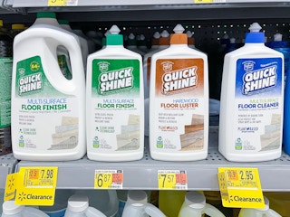 A variety of cleaning supplies sitting on a store shelf with clearance stickers and price stickers on the shelf.