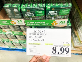 a person holding the price sign in costco in front of irish spring soap