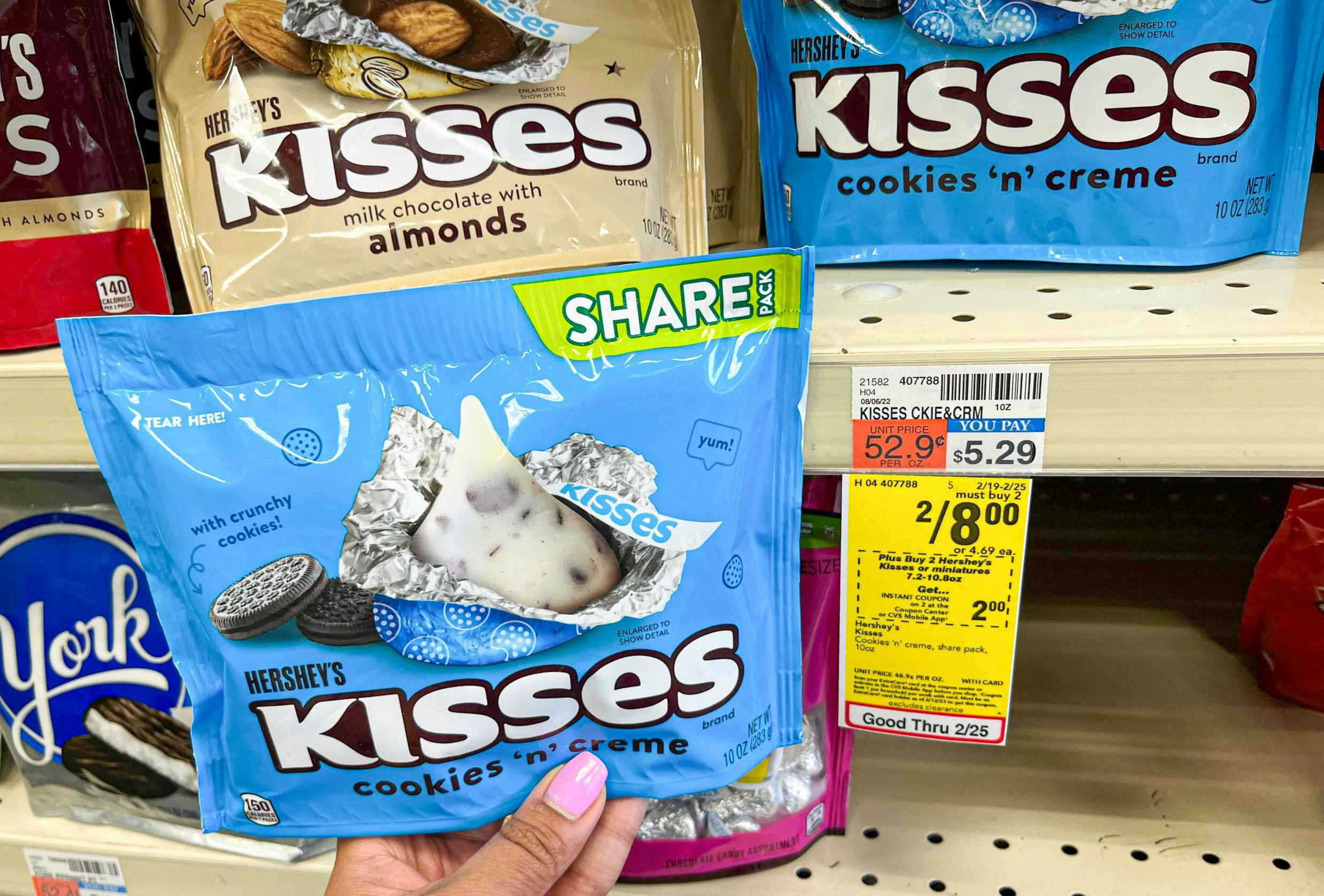 hand holding bag of Hershey's kisses next to sales tag