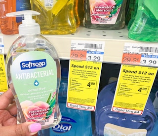 hand holding bottle of Softsoap hand soap next to sales tag