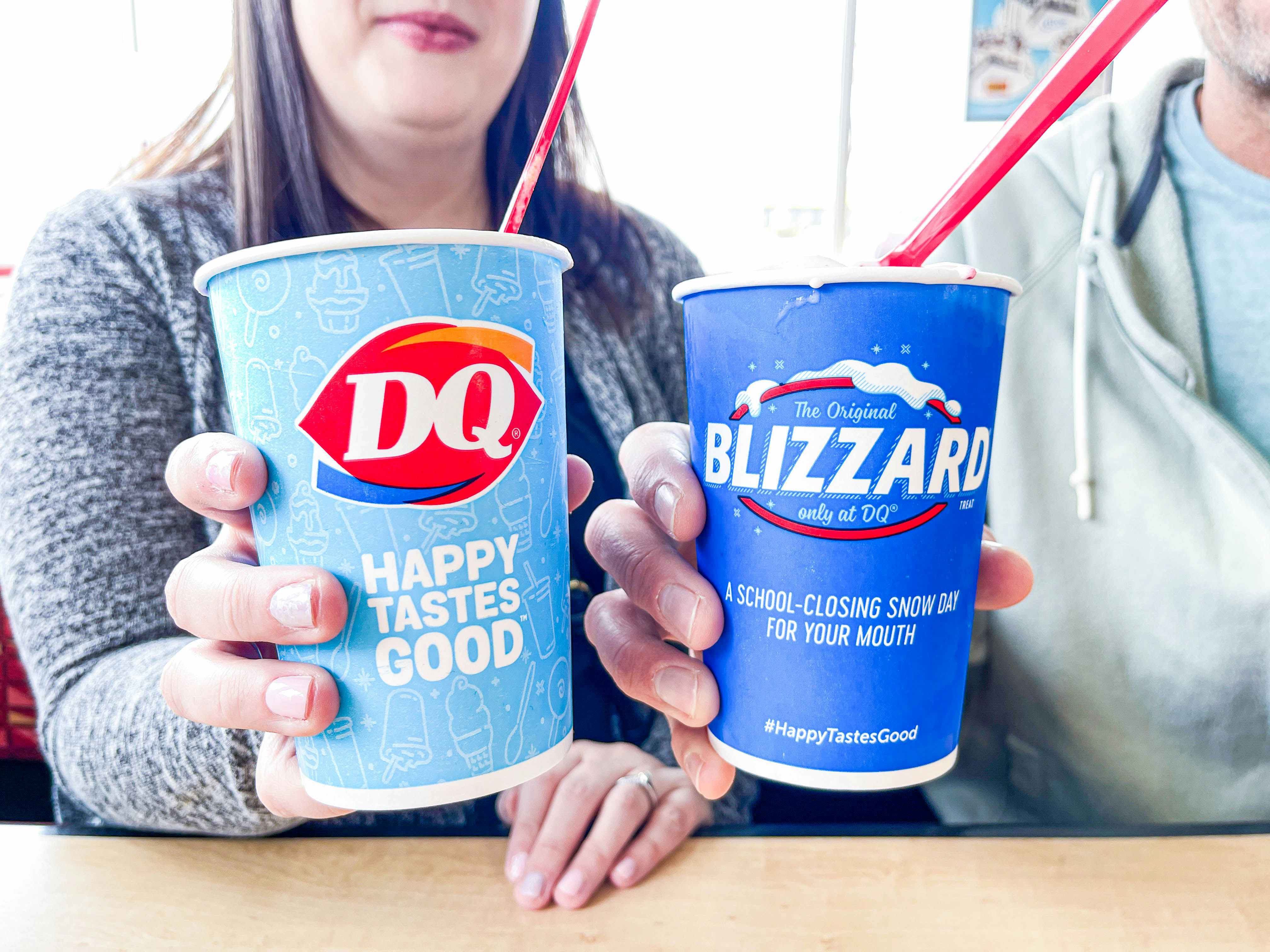 two people holding up two dairy queen blizards 