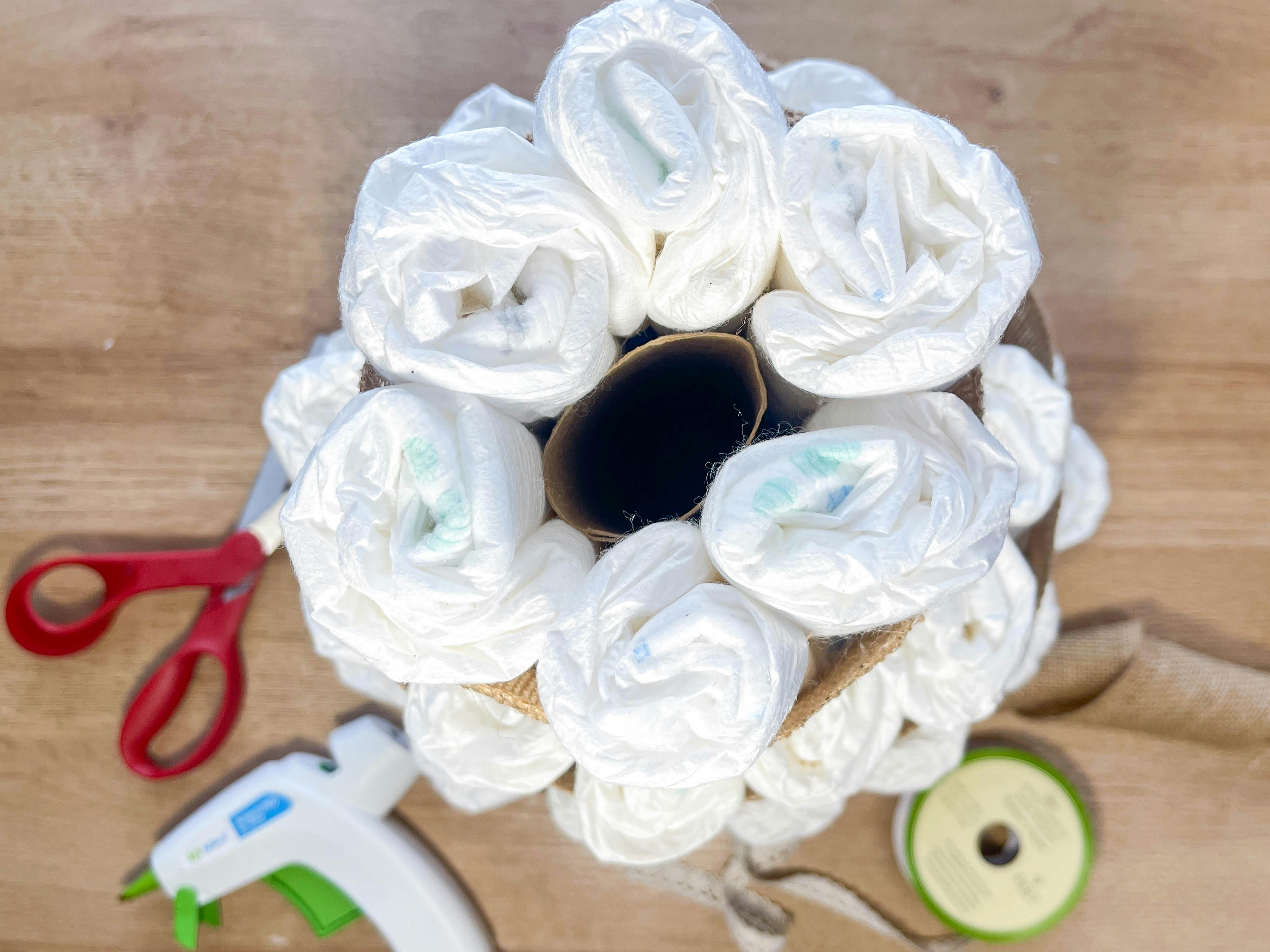 a top view of a diy diaper cake being made 