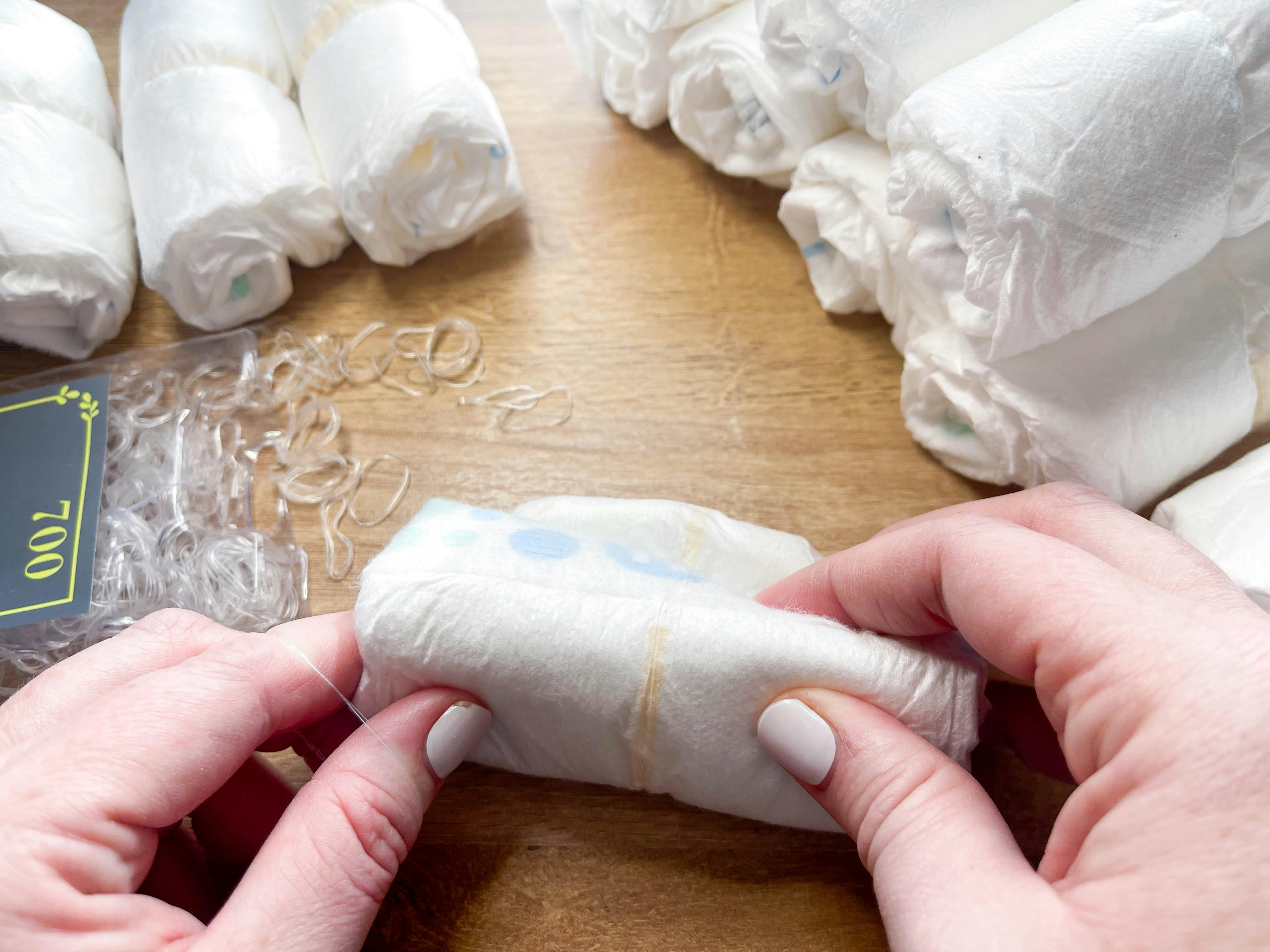 diapers on a table being rolled up for a craft 