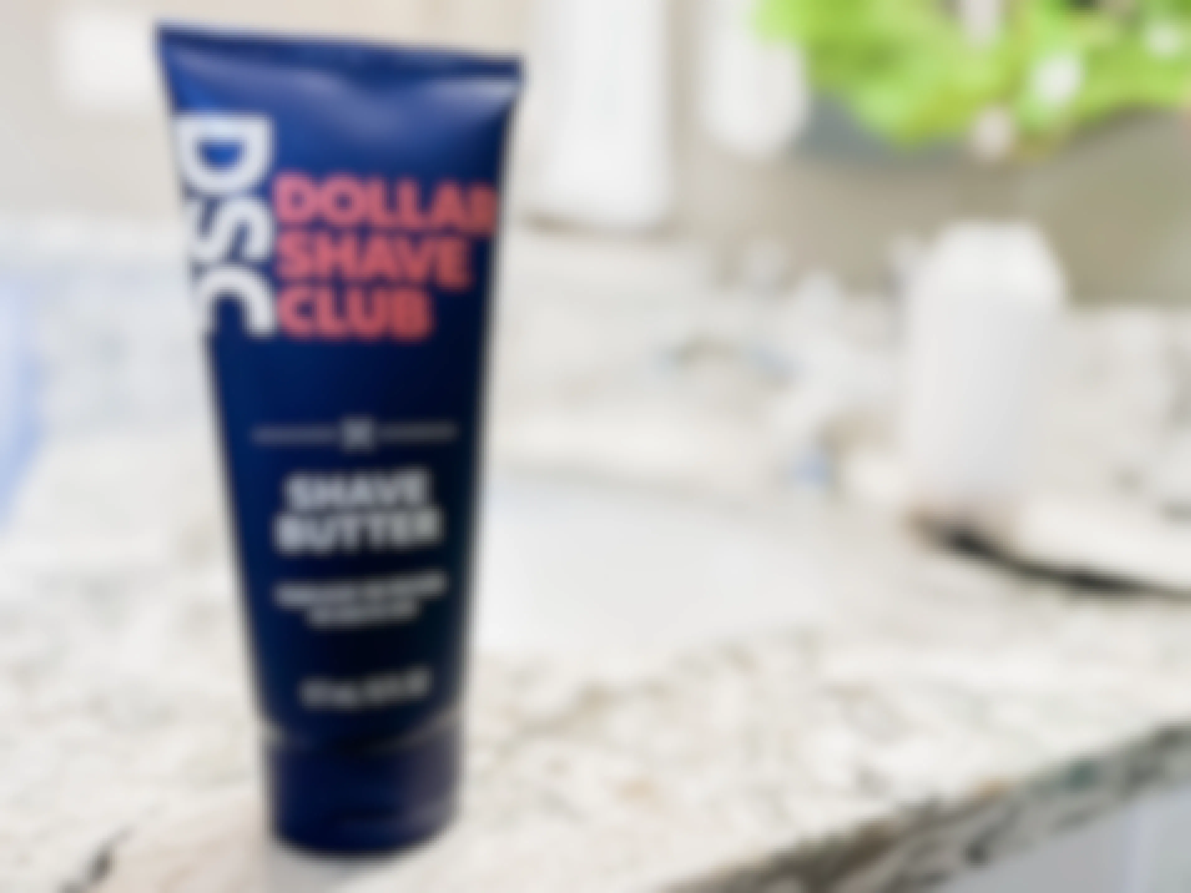 A bottle of the Dollar Shave Club Shave Butter on a bathroom countertop