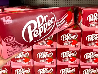 Someone taking a box of the new Dr Pepper Strawberries and Cream flavored soda from a shelf