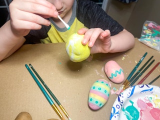 a little kid painting a potato with qtip