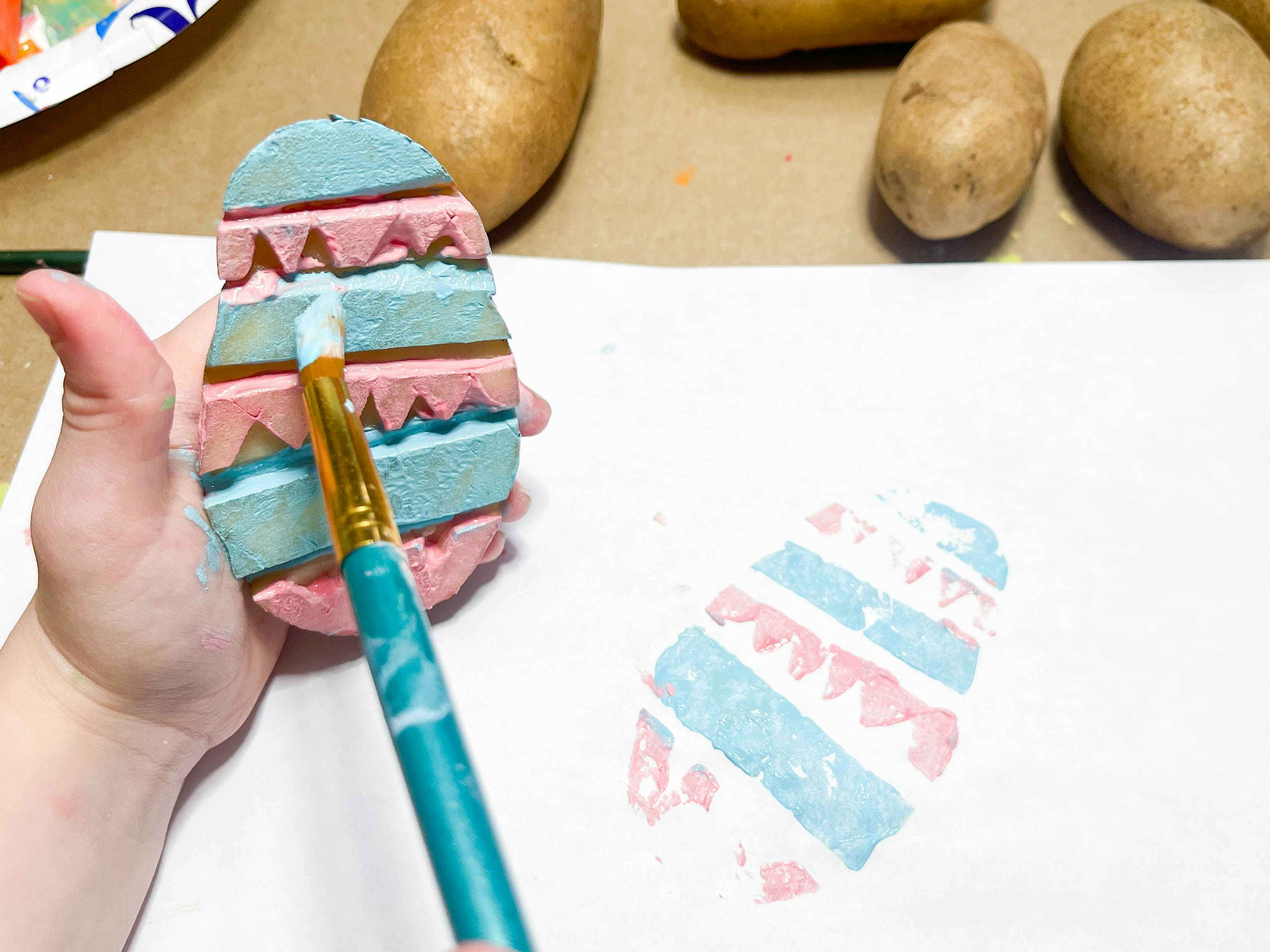 a person painting a potato stamp 