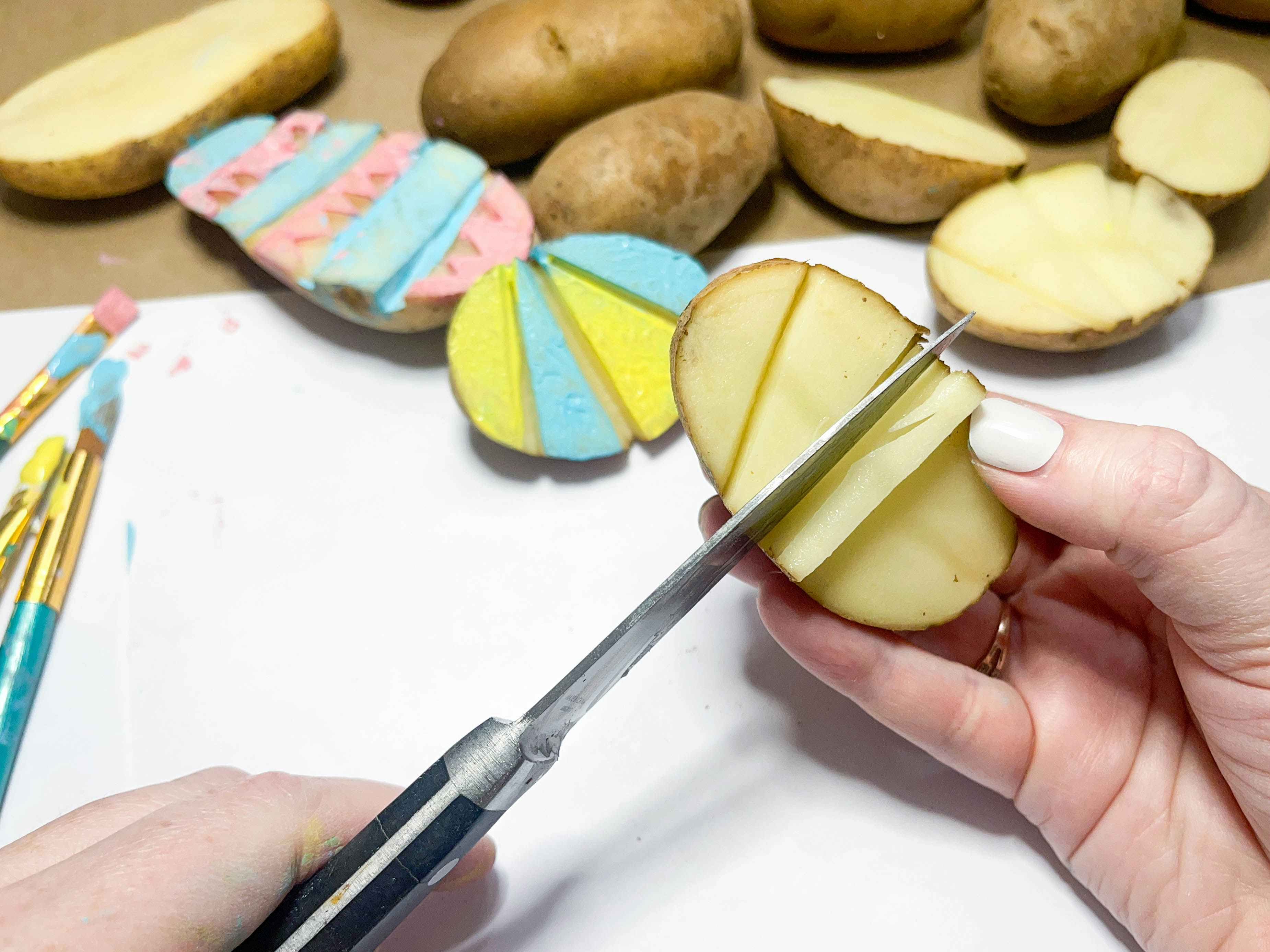 a person cutting a potato stamp