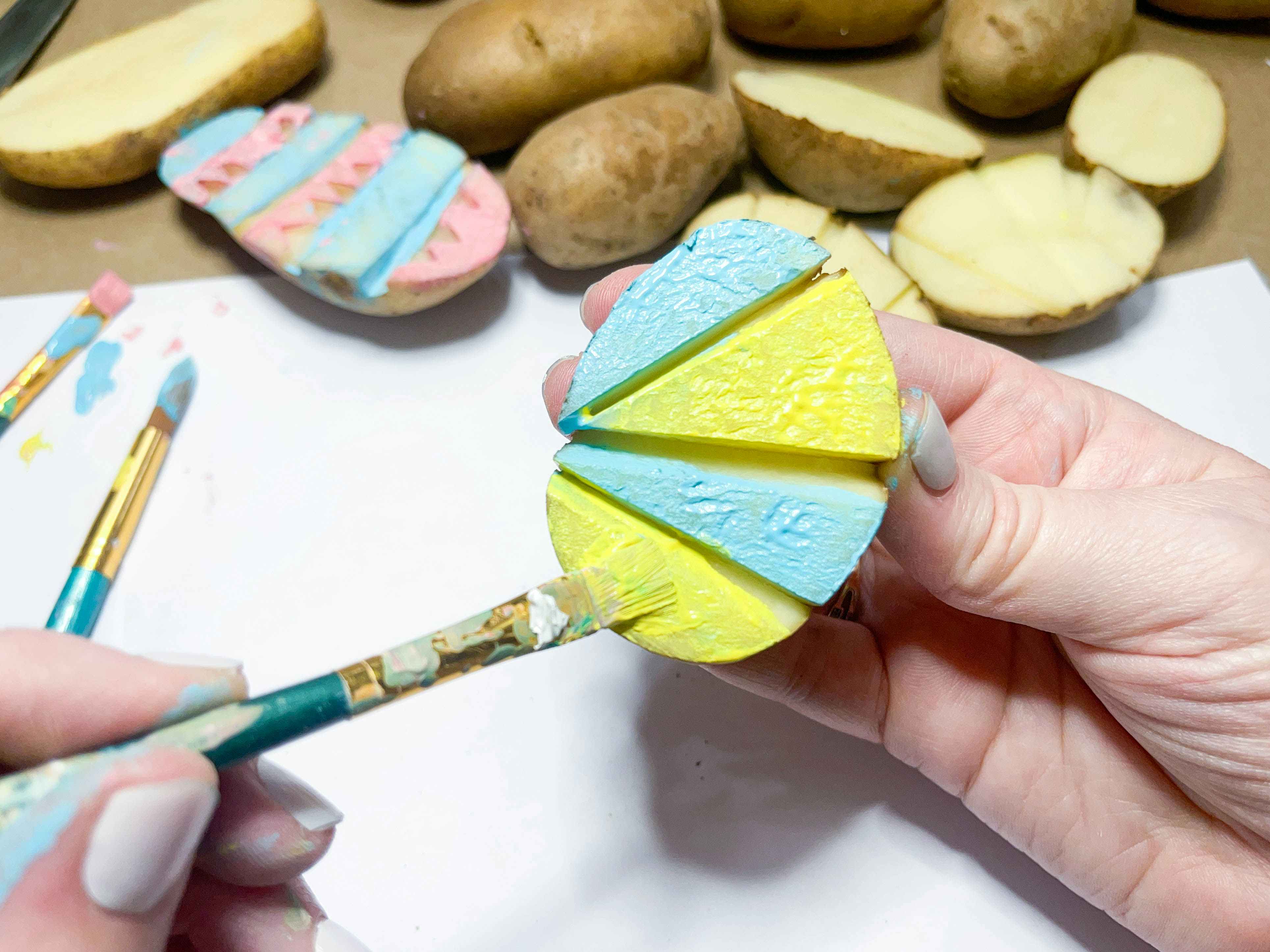 a person painting a potato stamp