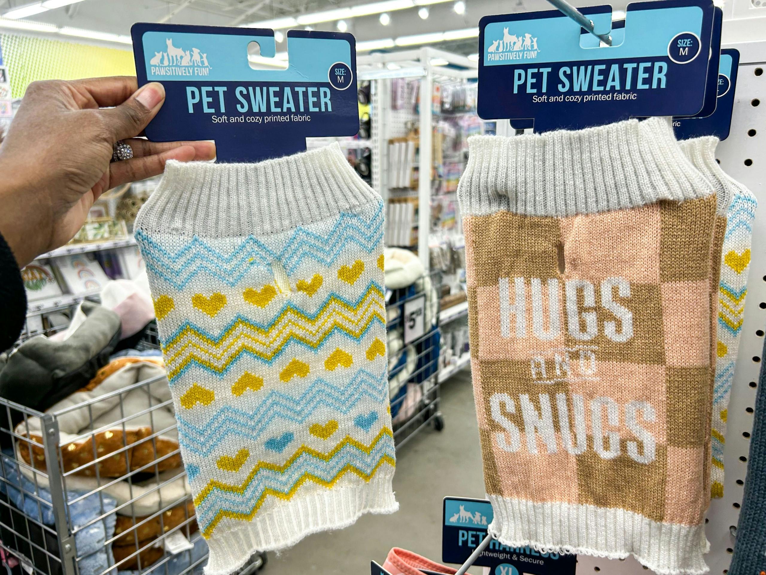 a hand holding up a pet sweater
