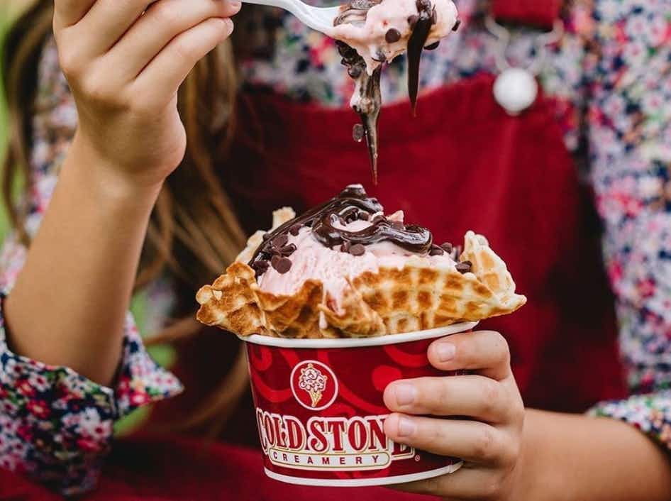a child holding an ice cream from cold stone.