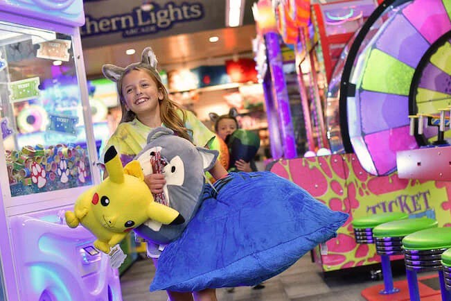 A child holding a bunch of prizes from the Northern Lights Arcade at Great Wolf Lodge