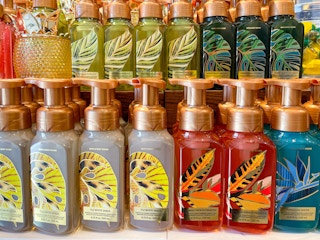 A variety of hand soaps sitting on a store shelf.