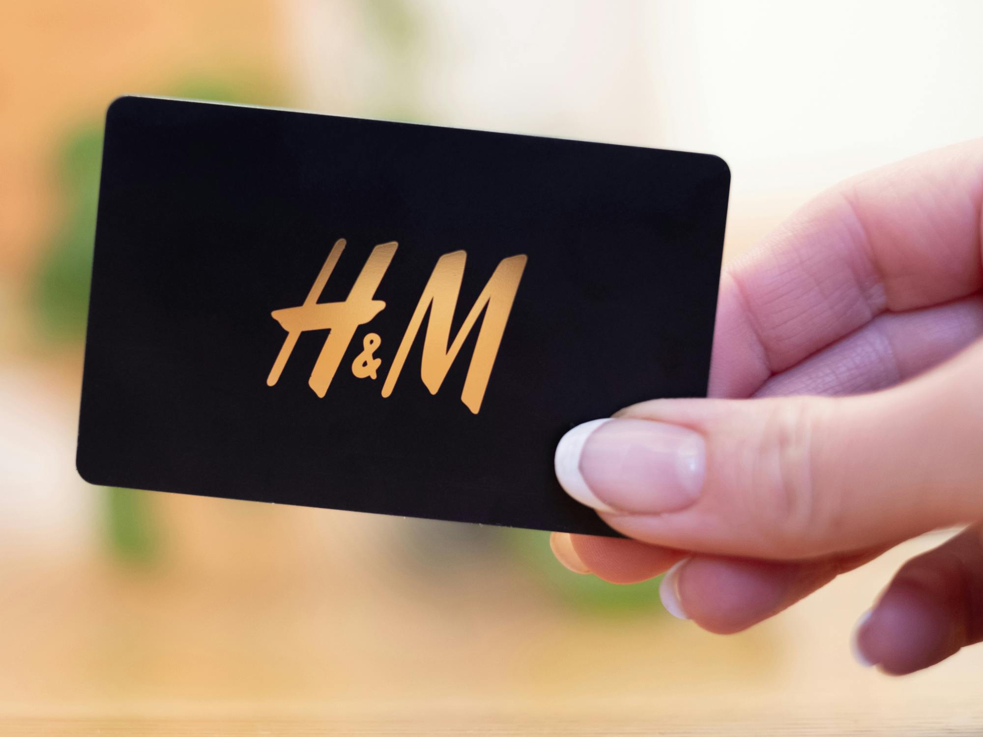 person holding a black h&m gift card