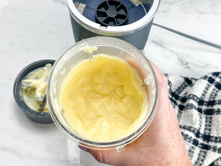 a person using a nutribullet blender to mix homemade dole whip 