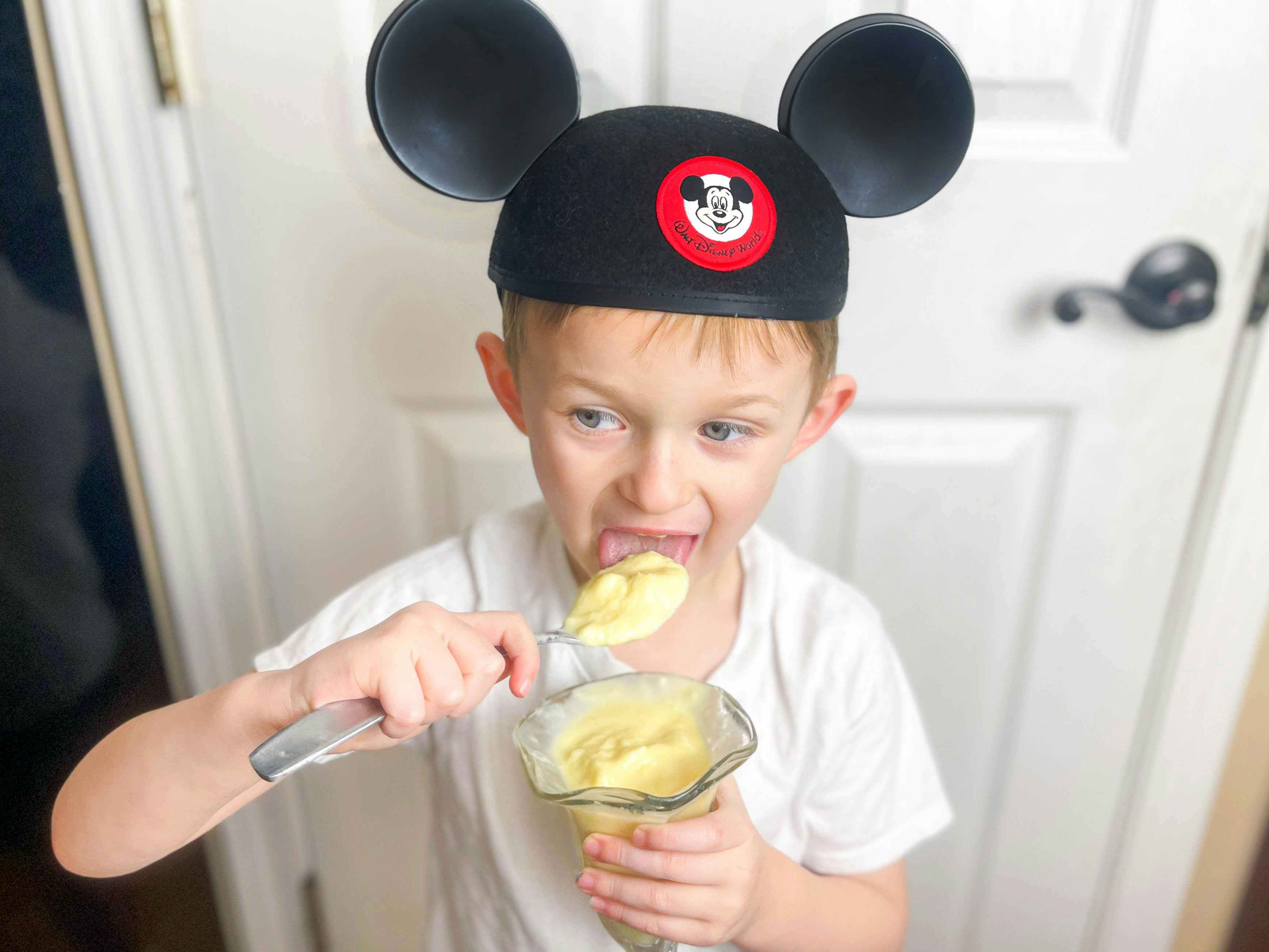 a child eating homemade dole whip wearing a Disneywold Mickey ears hat