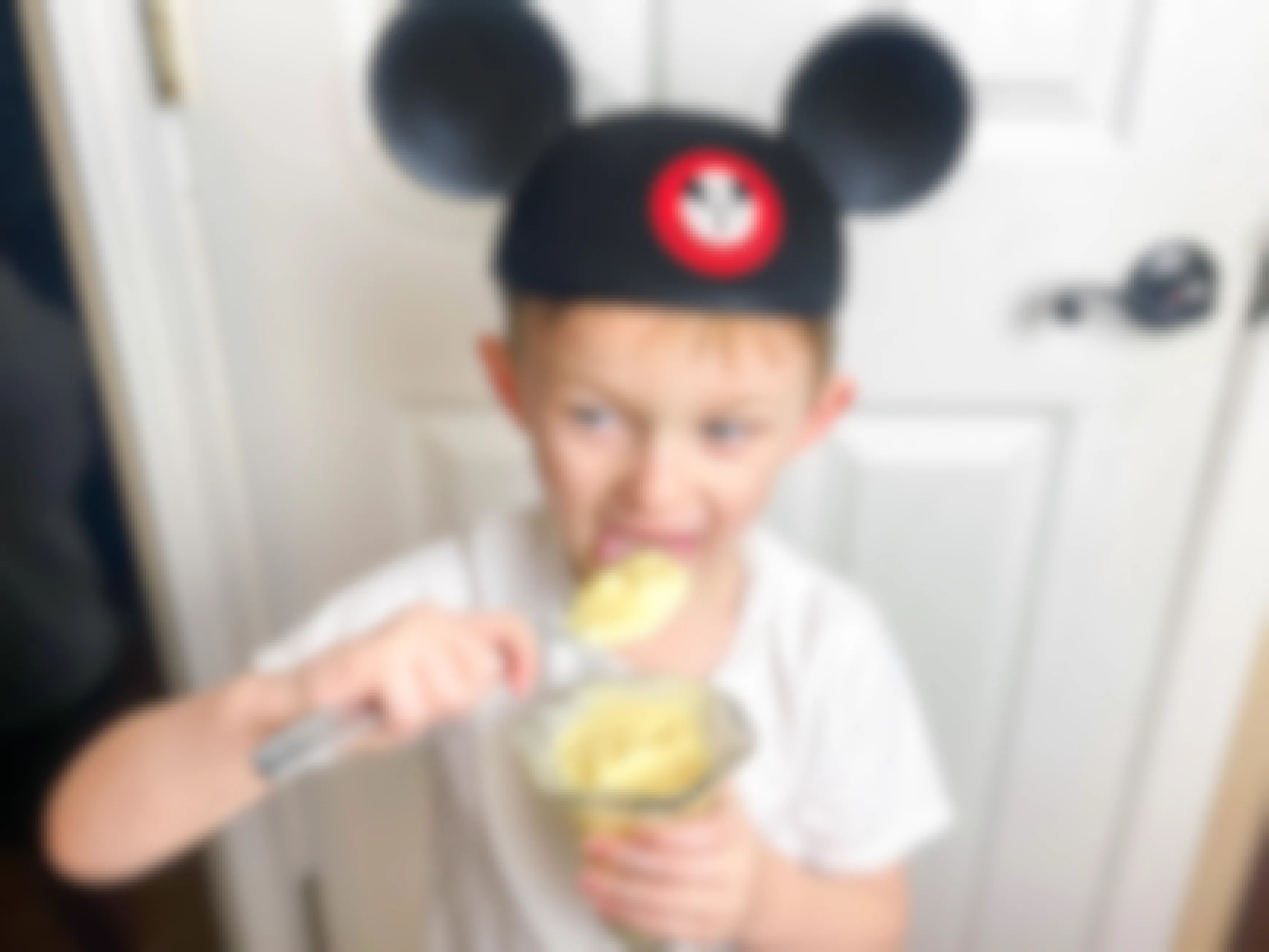 a child eating homemade dole whip wearing a Disneywold Mickey ears hat