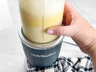 a person using a nutribullet blender to mix homemade dole whip