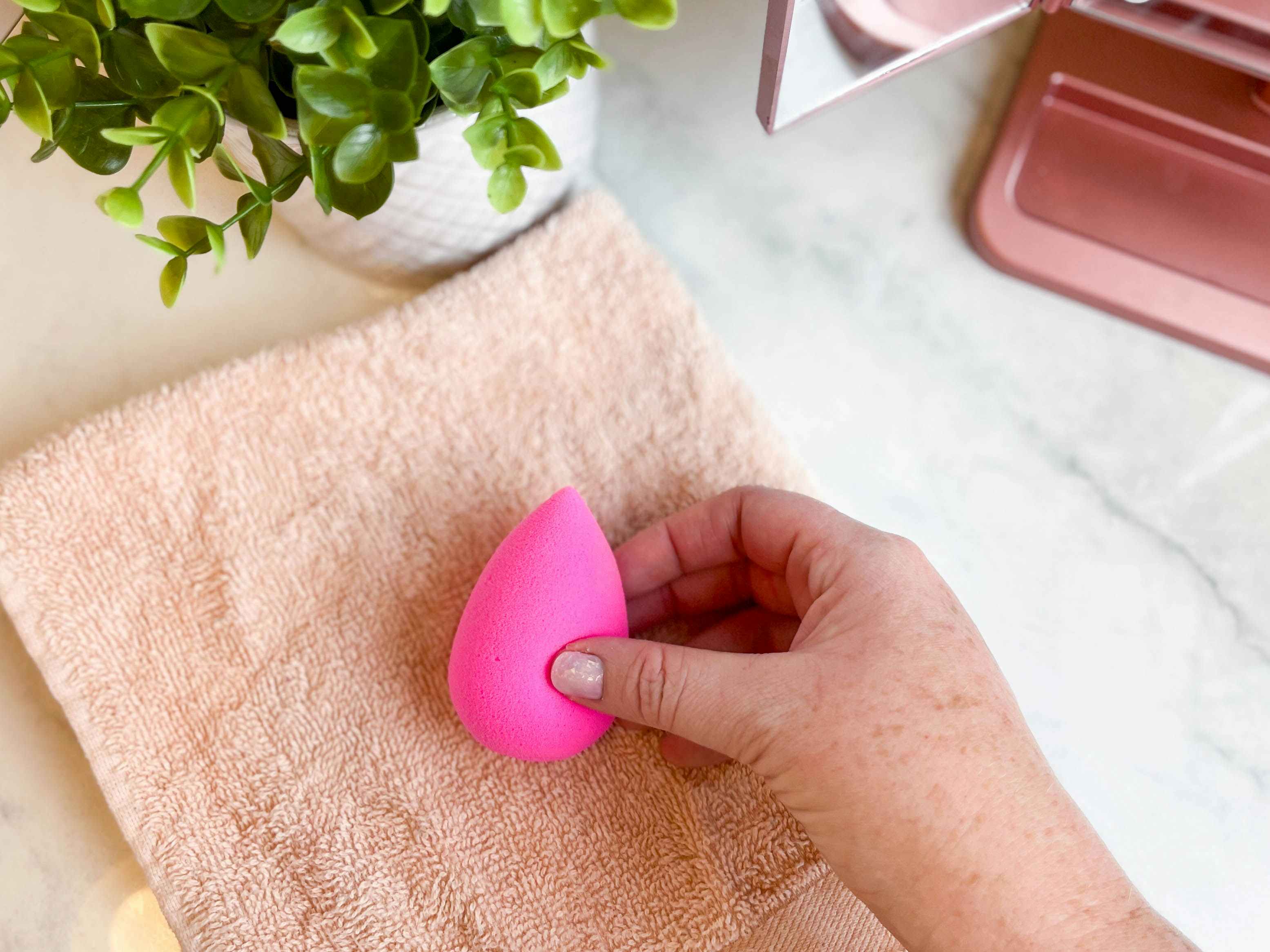 a person placing a beauty blender on a towel to dry