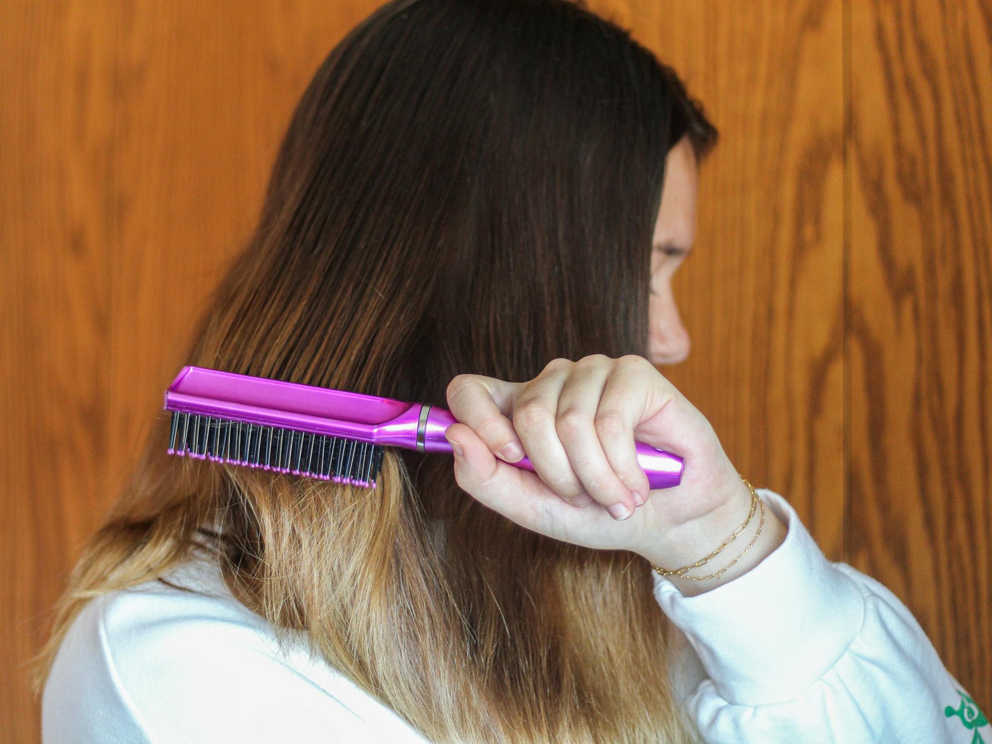 person brushing their hair with a hairbrush