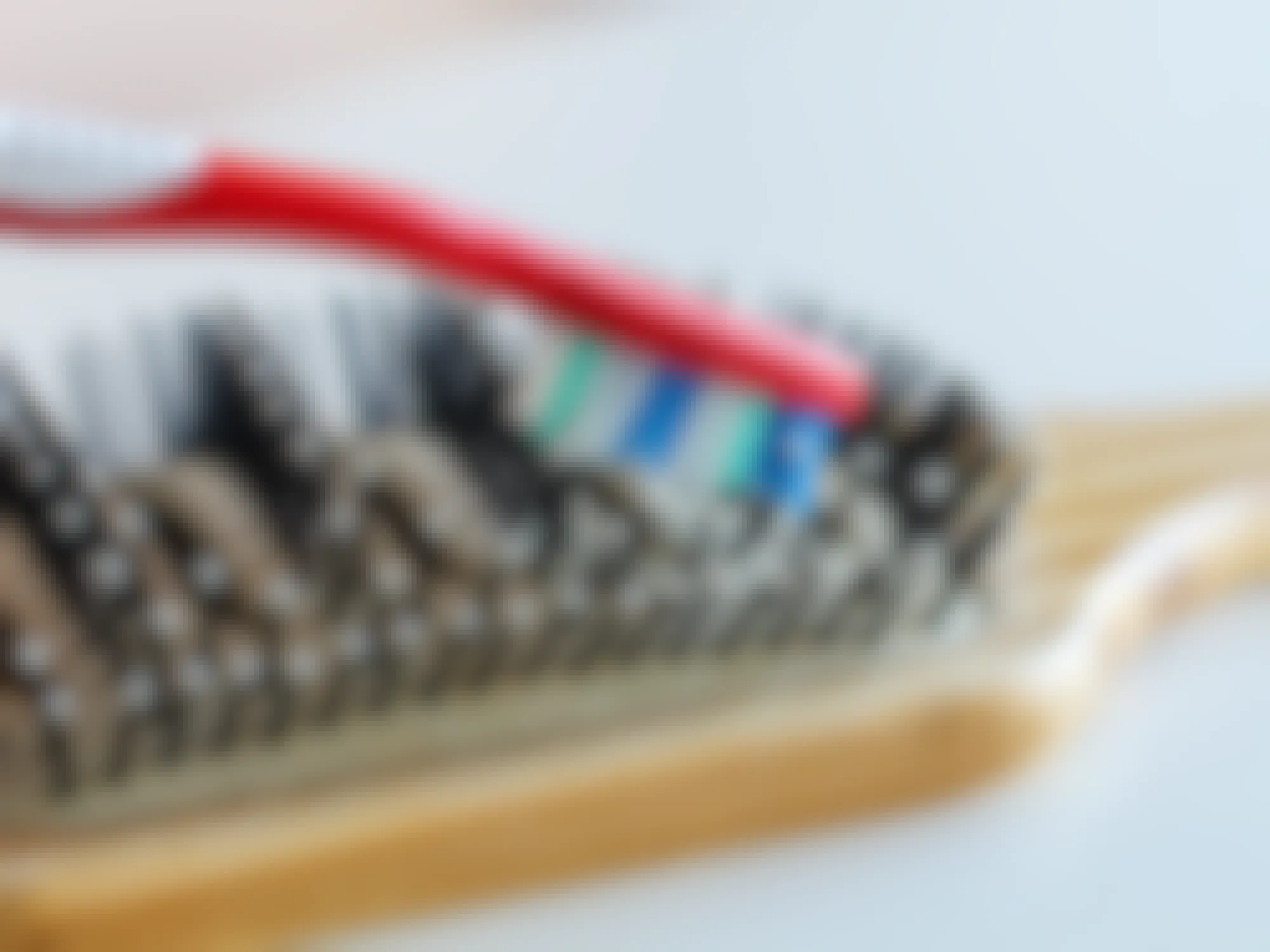 a toothbrush cleaning the bristles of a wooden hairbrush