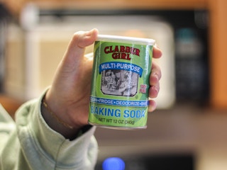 a person holding a can of baking soda