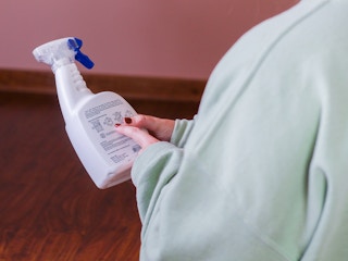 a person looking at the back of a spray cleaning solution