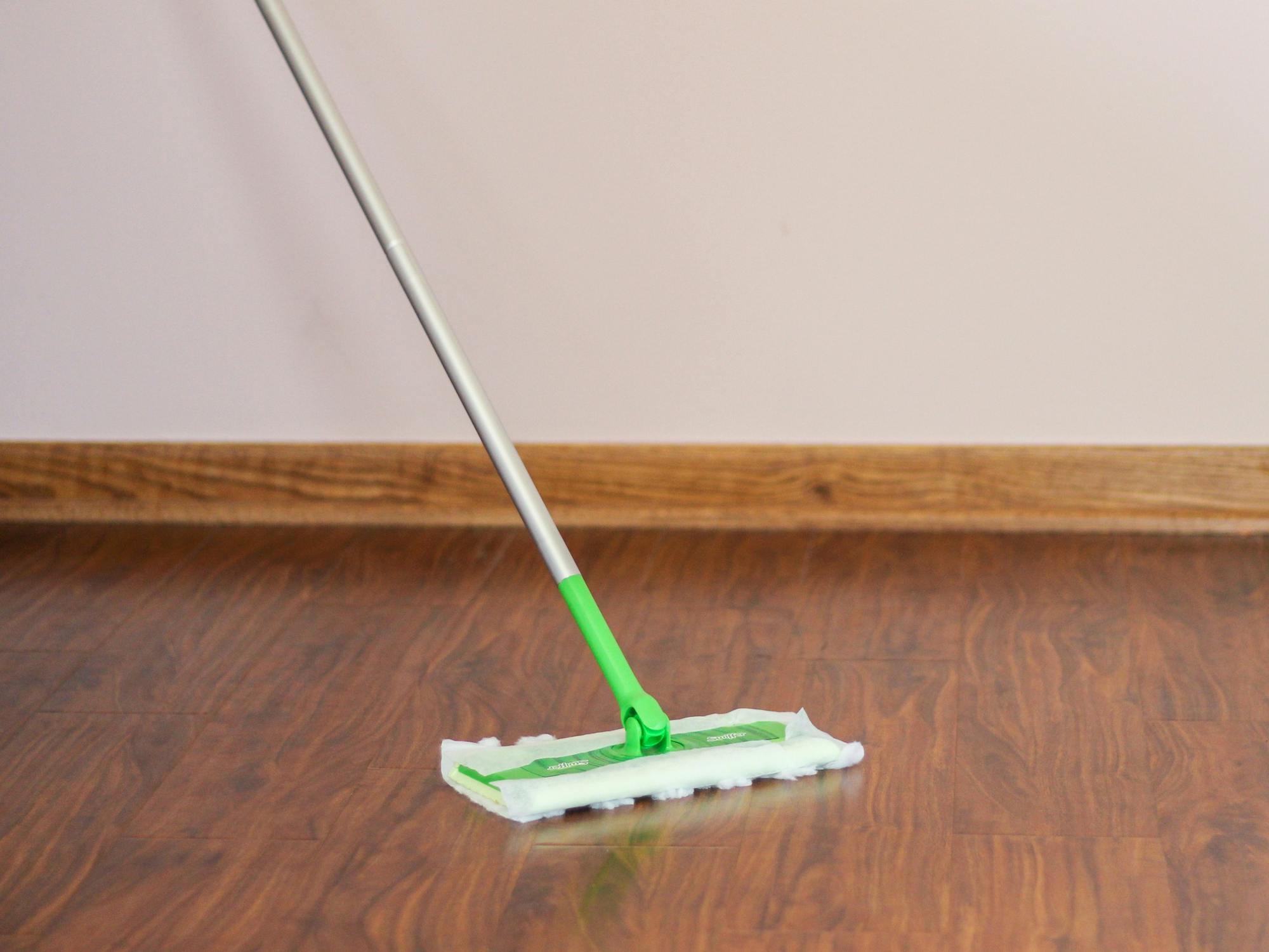 a person using a swifter on hardwood floors