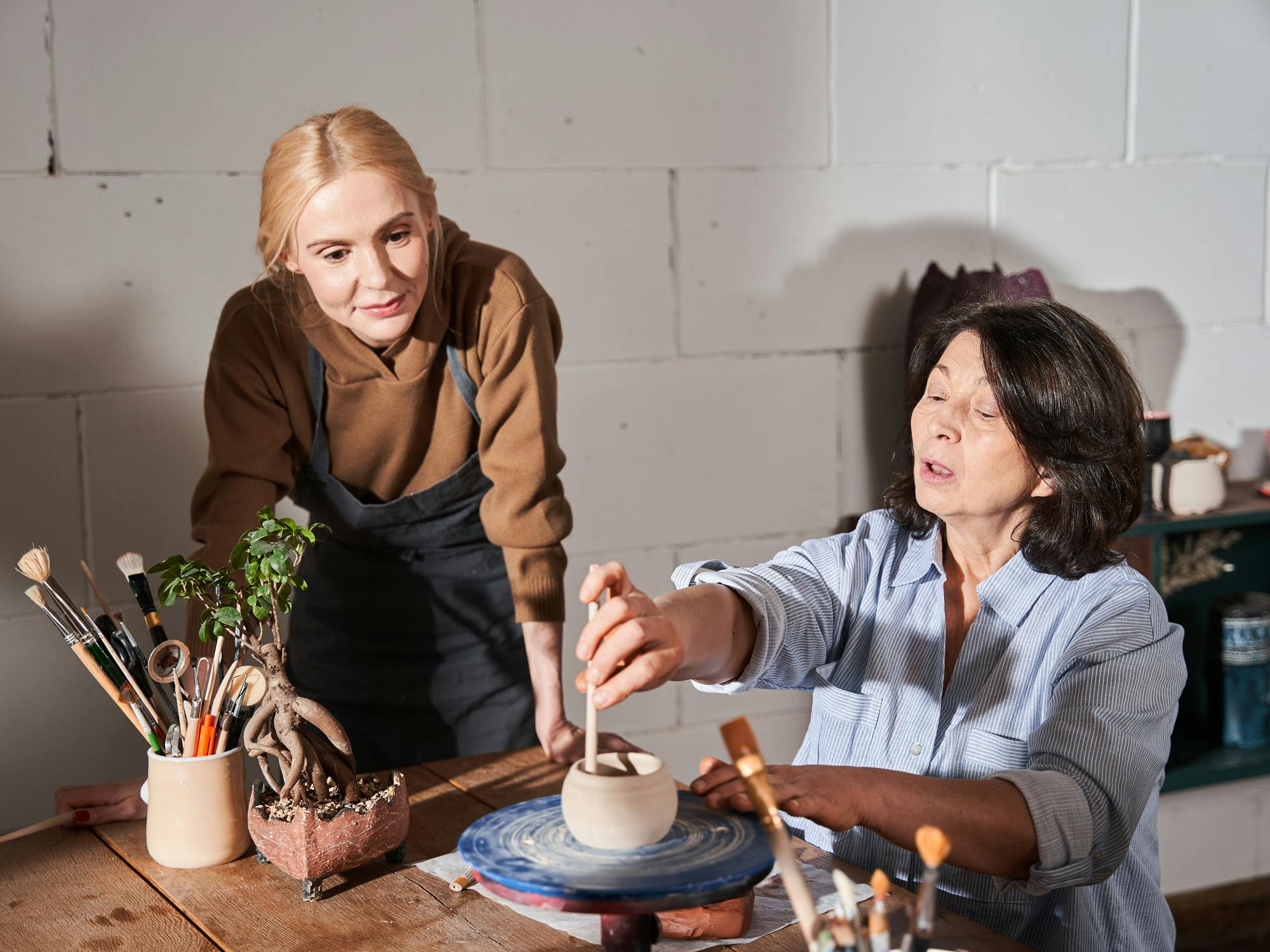 two people making pottery 