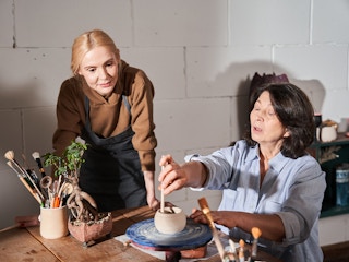 two people making pottery 