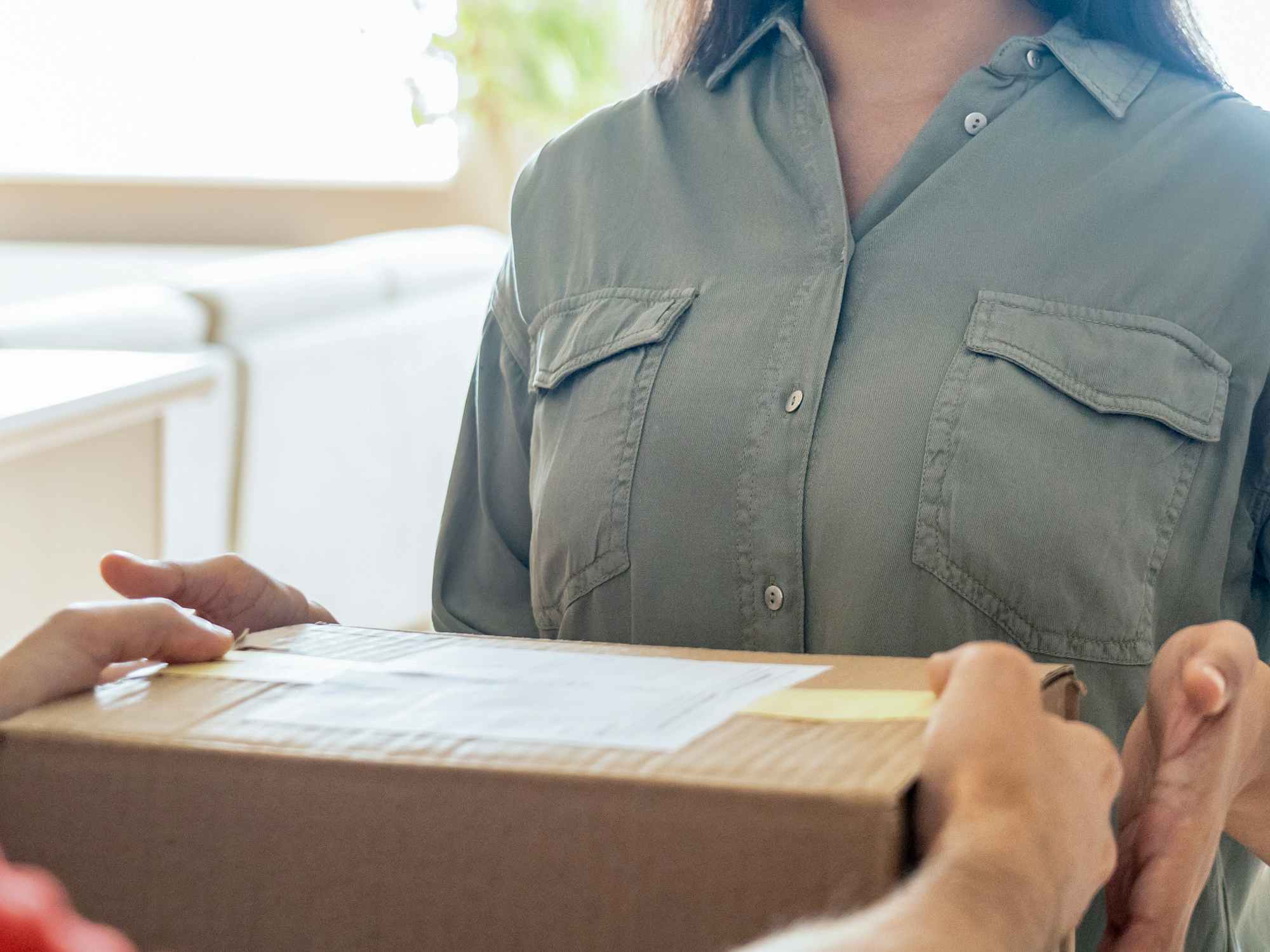 a person receiving a delivery box at home