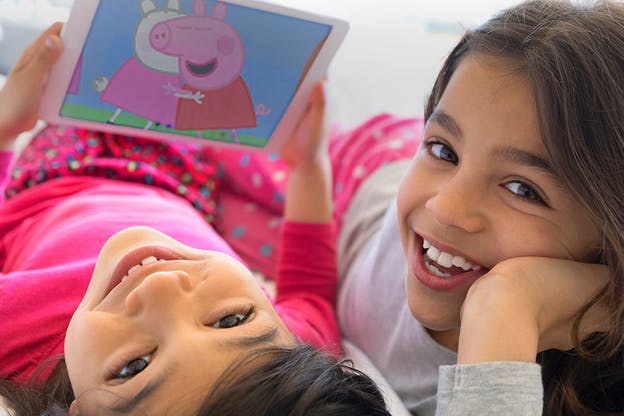 Two children looking while playing peppa pig on noggin