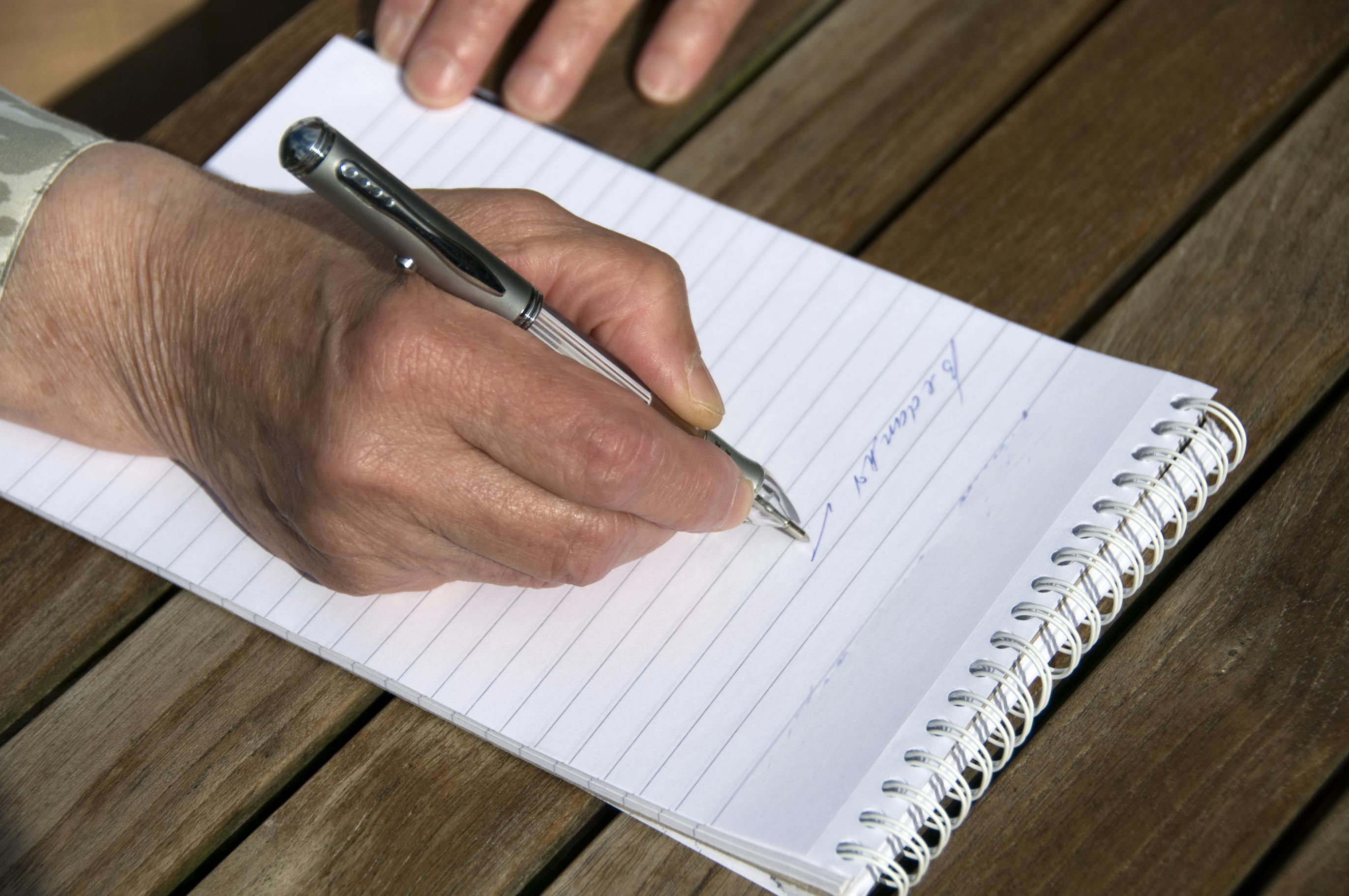 Older person writing a note