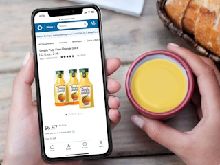 person with glass of orange juice looking at product on sams website on phone