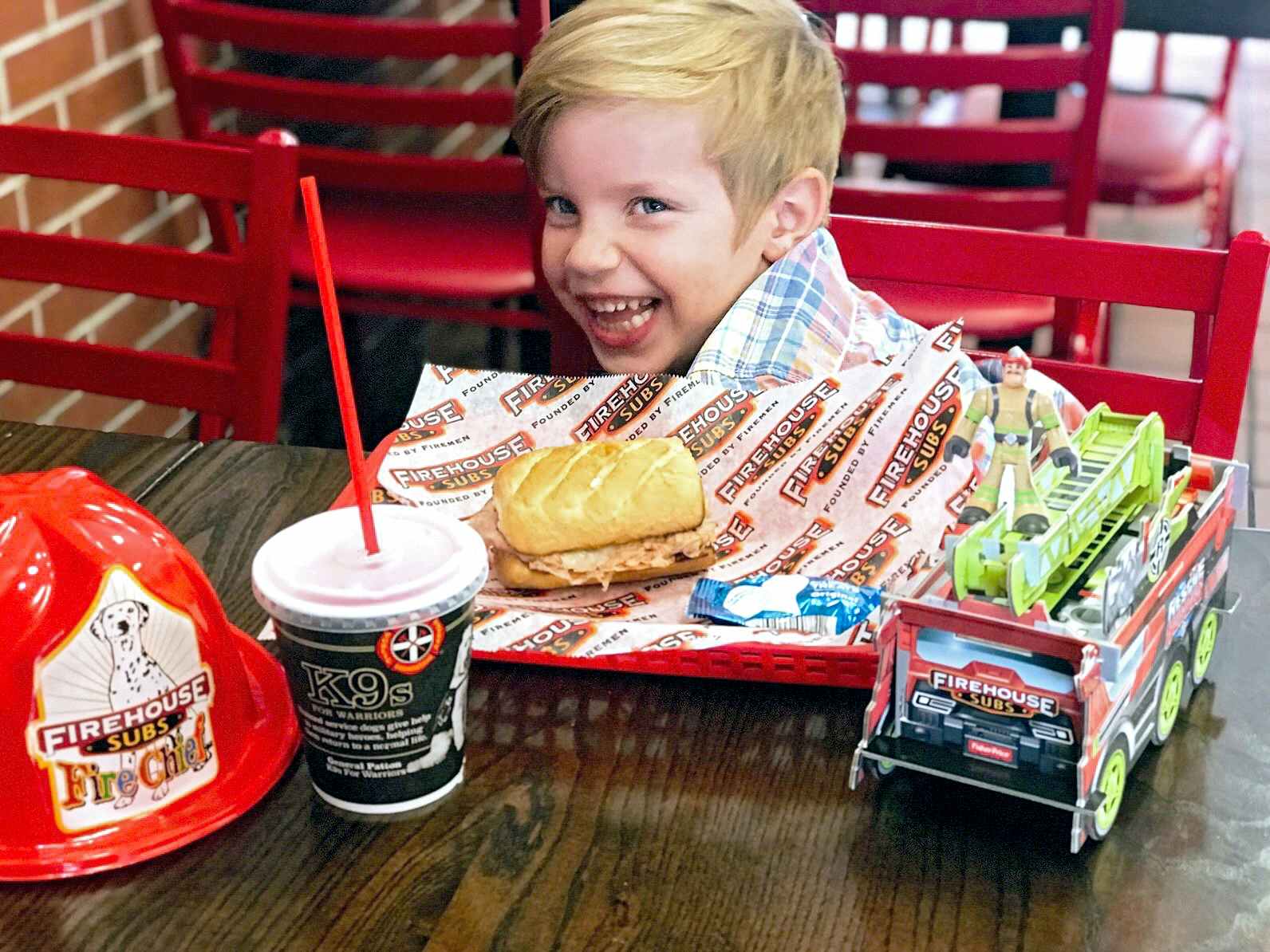 happy child eating a kids meal at firehouse subs restaurant