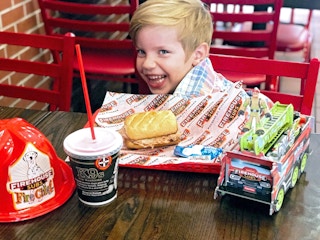 happy child eating a kids meal at firehouse subs restaurant
