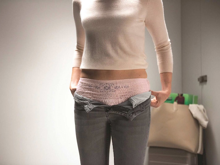 person wearing depend underwear pulling on pants