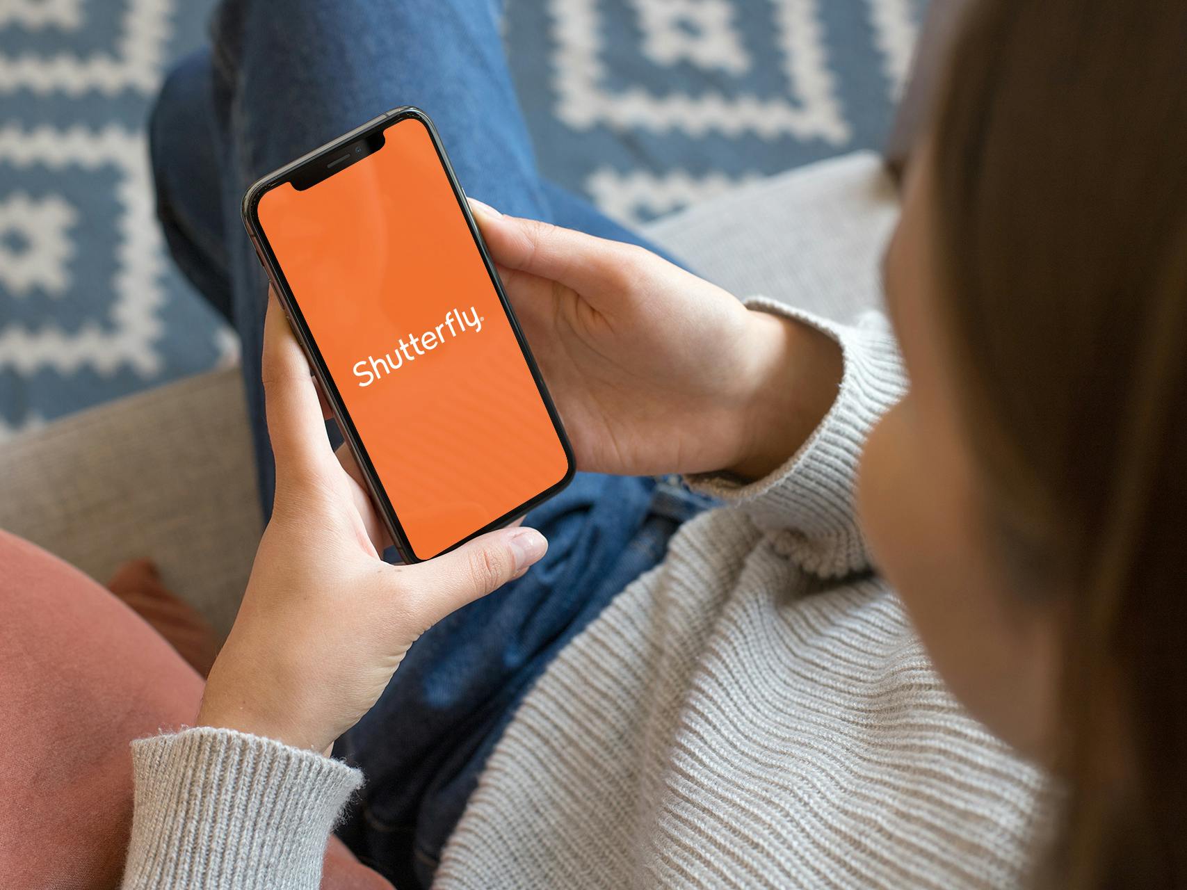 person launching shutterfly app on iphone