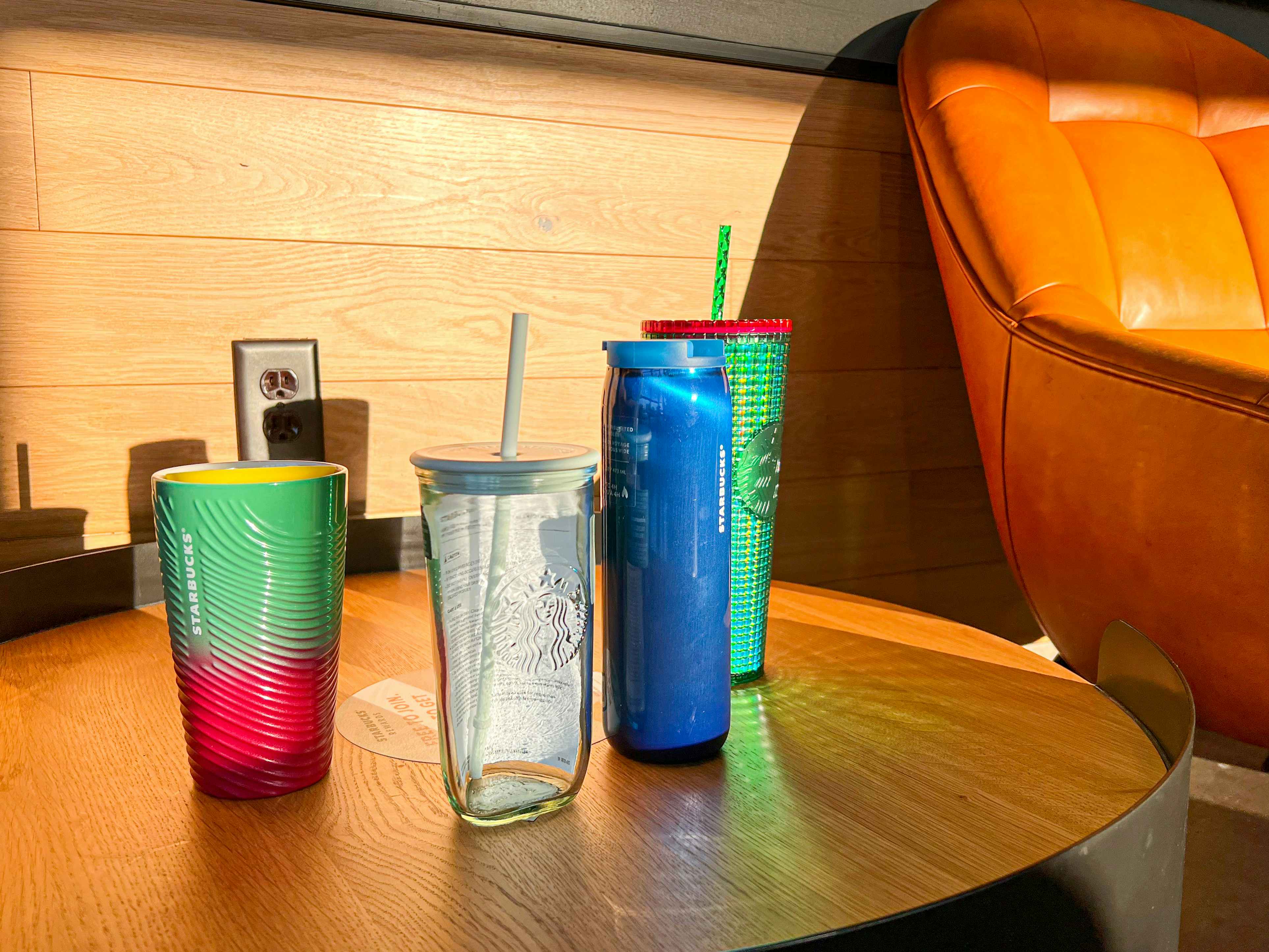 Four stabucks cups on a counter inside cafe