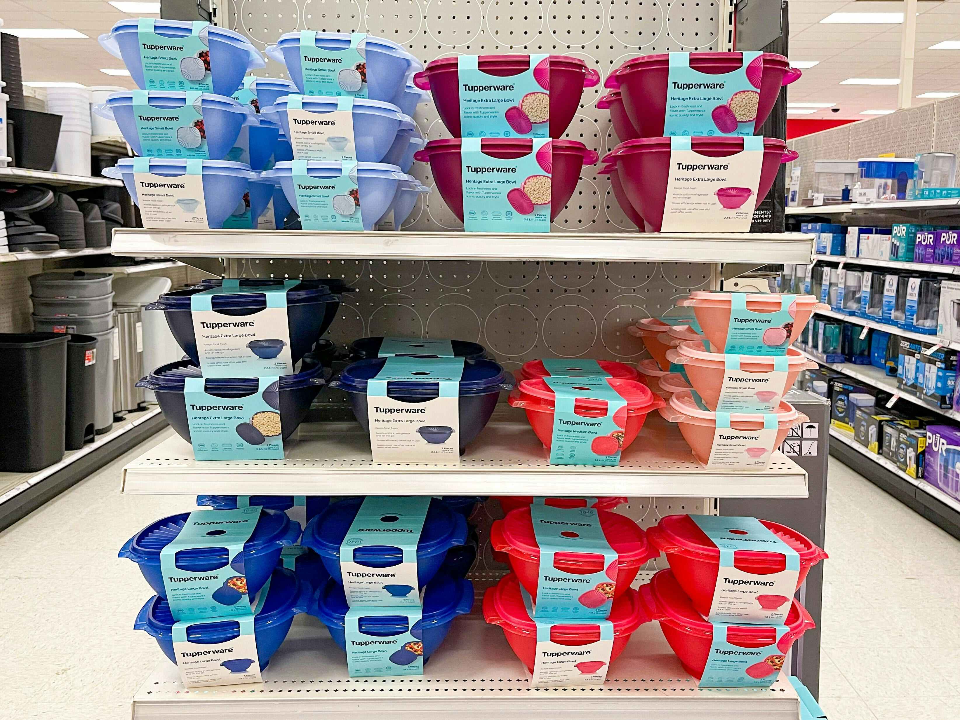 A variety of blue and red tupperware bowls on the endcap shelf at target