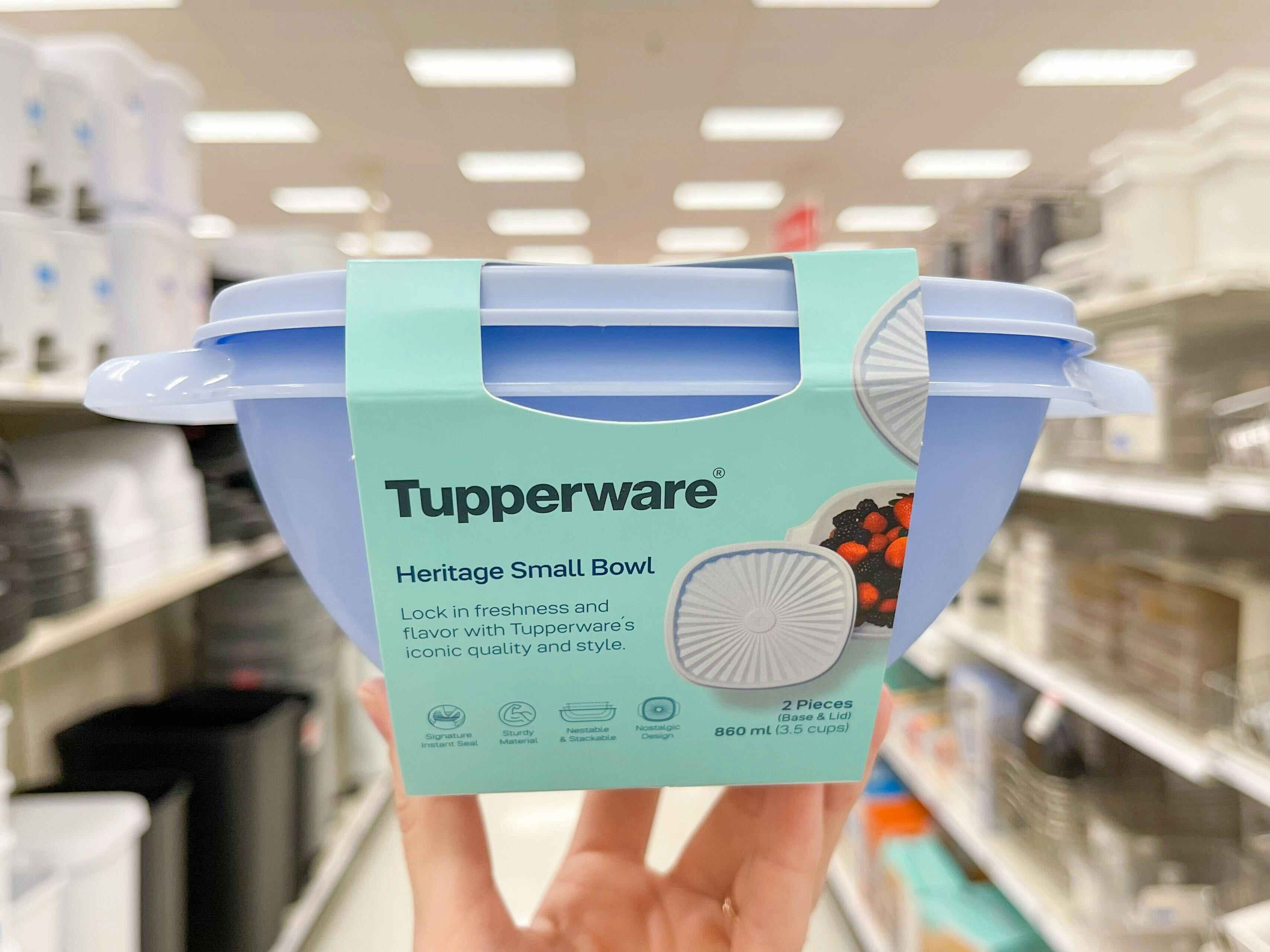 a hand holding up a tupperware container in a Target store aisle