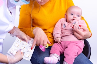 A mom choosing the earrings she wants for her infant