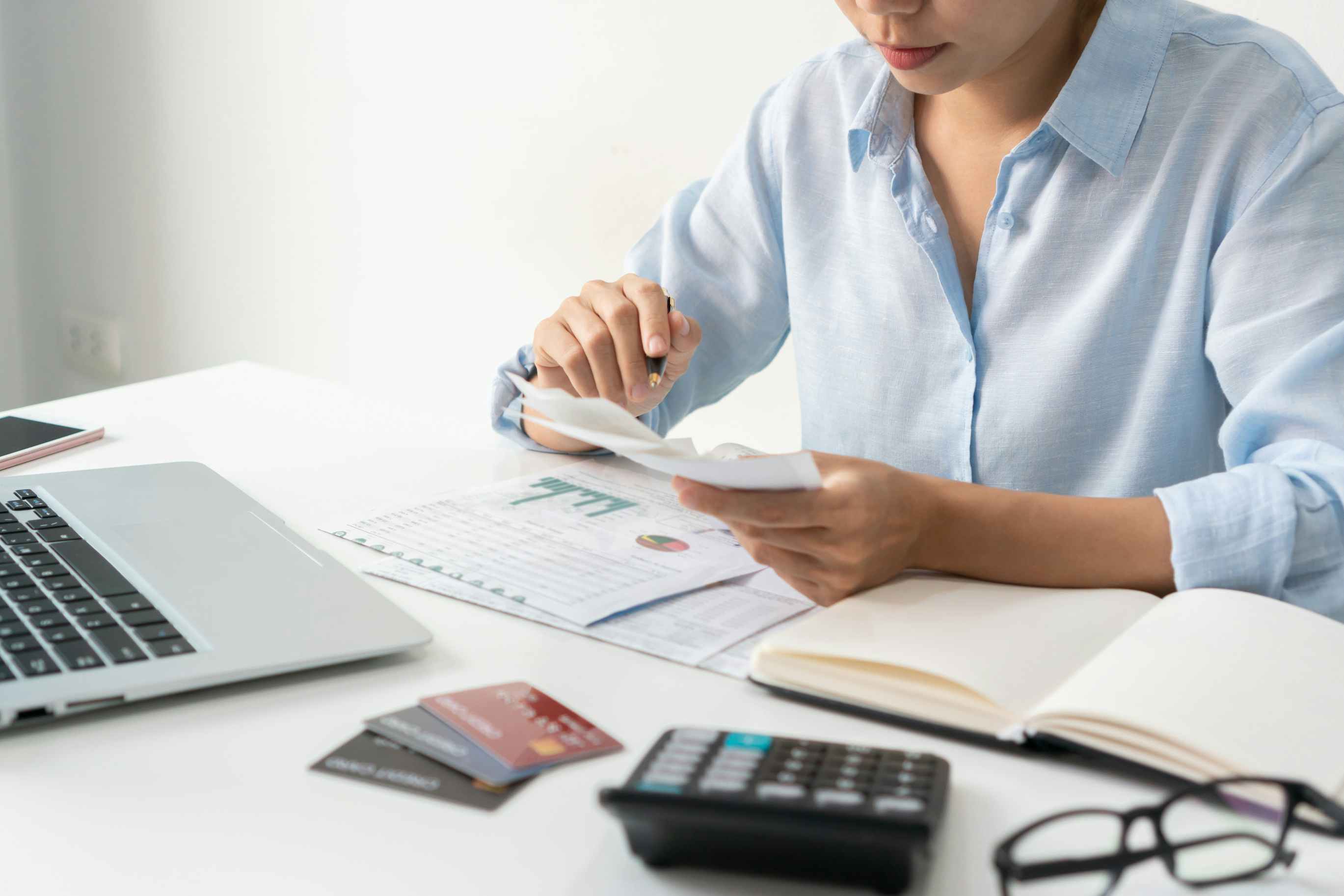 Woman Calculating debt on credit card 