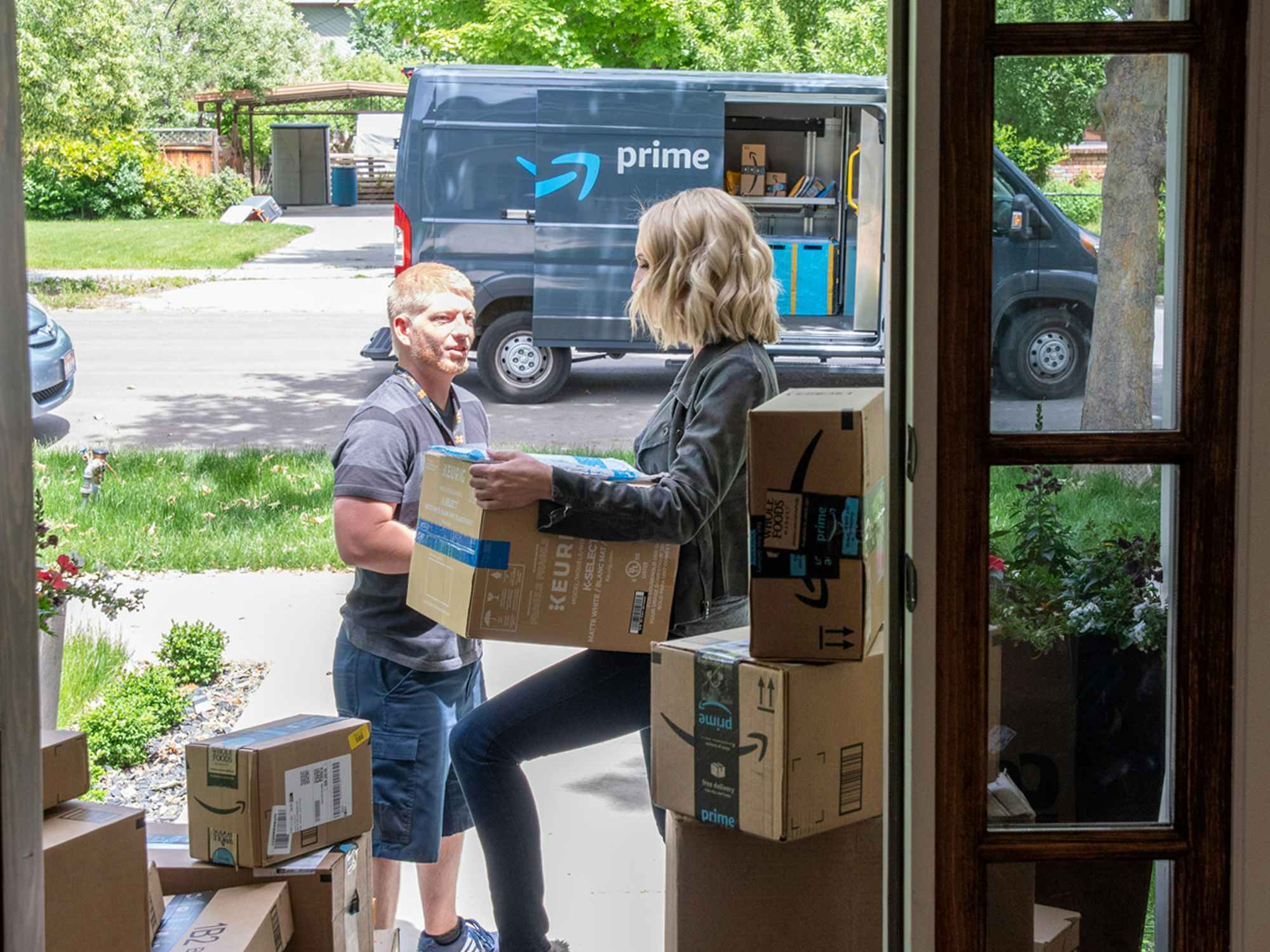 A person accepting an Amazon delivery outside their front door