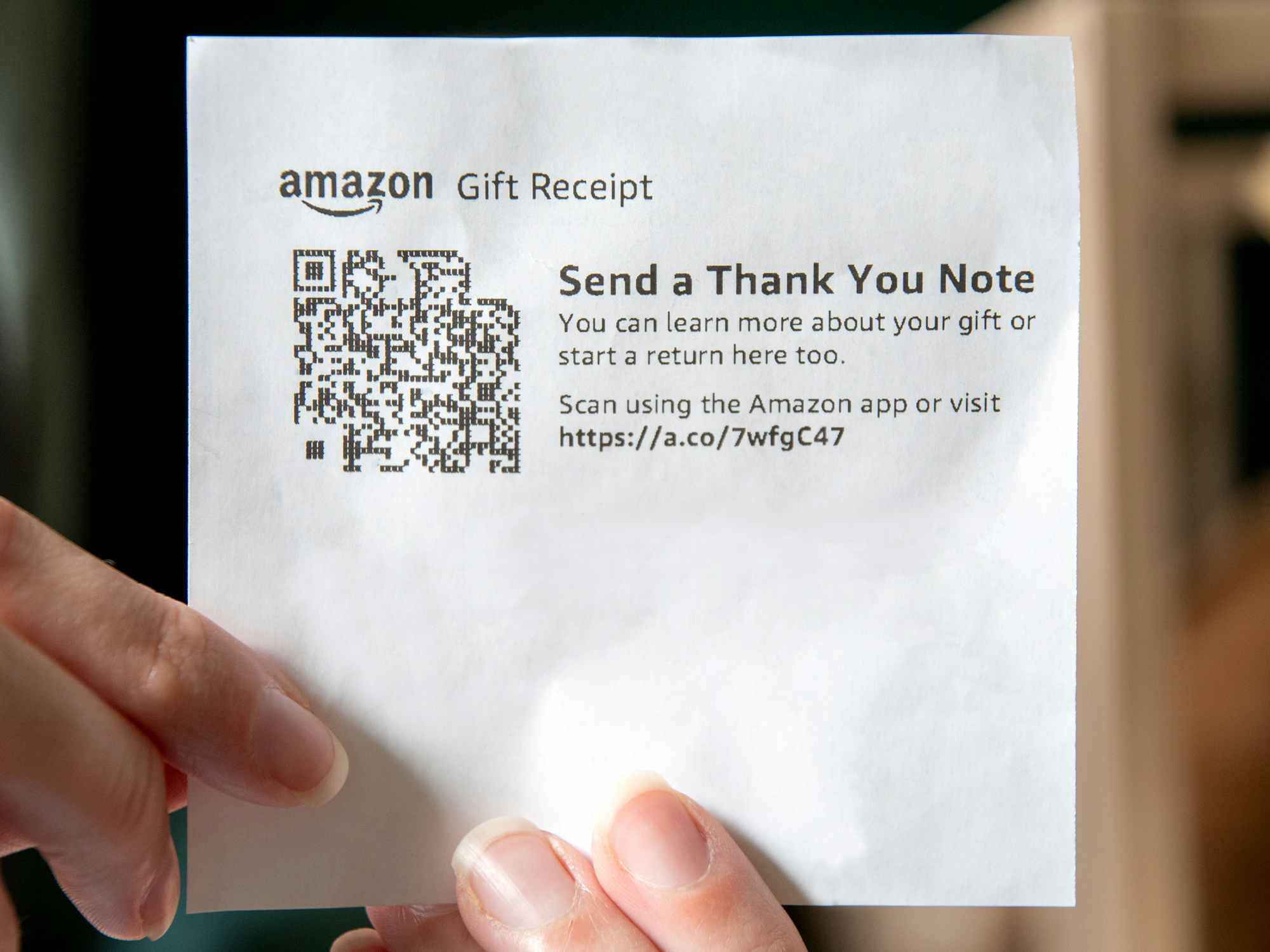 person holding an amazon gift receipt with qr code