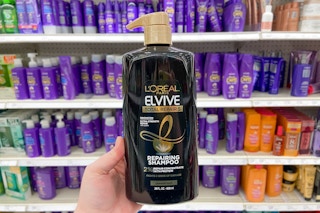 hand holding a jumbo bottle of l'oreal total repair shampoo